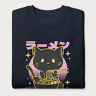 Folded navy blue sweatshirt with Japanese text and a neon outline graphic of a cat eating ramen.