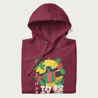 Folded maroon hoodie with Japanese text and a retro graphic of a robot warrior holding a sword.