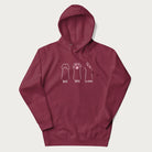 Maroon hoodie with graphic of cat paws playing rock-paper-scissors.