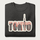 Folded dark grey sweatshirt with a graphic of Tokyo's skyline integrated within the letters spelling "TOKYO."