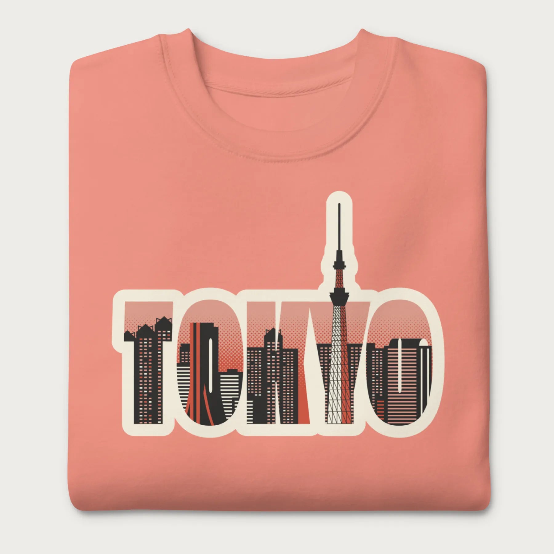 Folded light pink sweatshirt with a graphic of Tokyo's skyline integrated within the letters spelling "TOKYO."