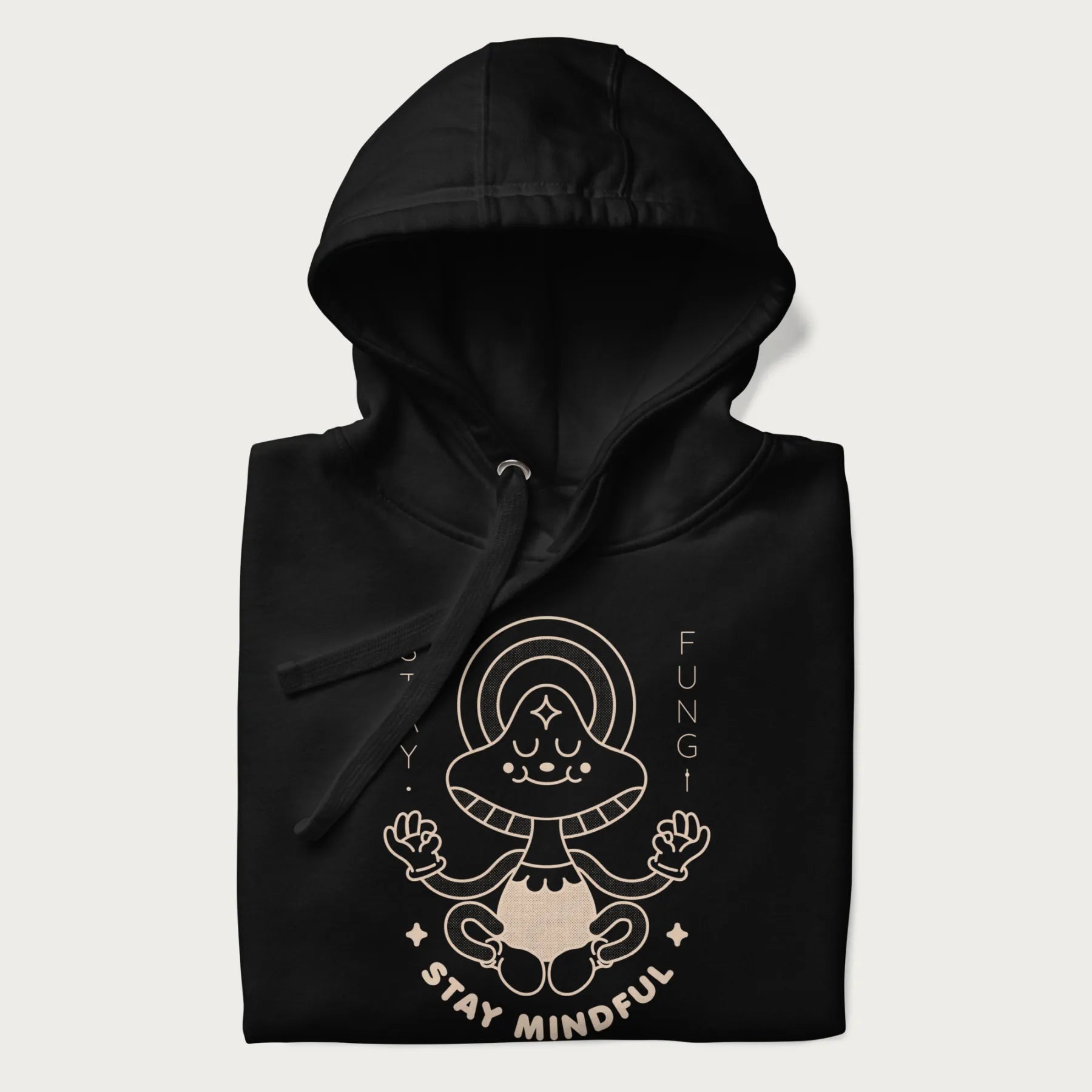 Folded black hoodie with a graphic of a meditating mushroom character and the words 'Stay Fungi' and 'Stay Mindful'.