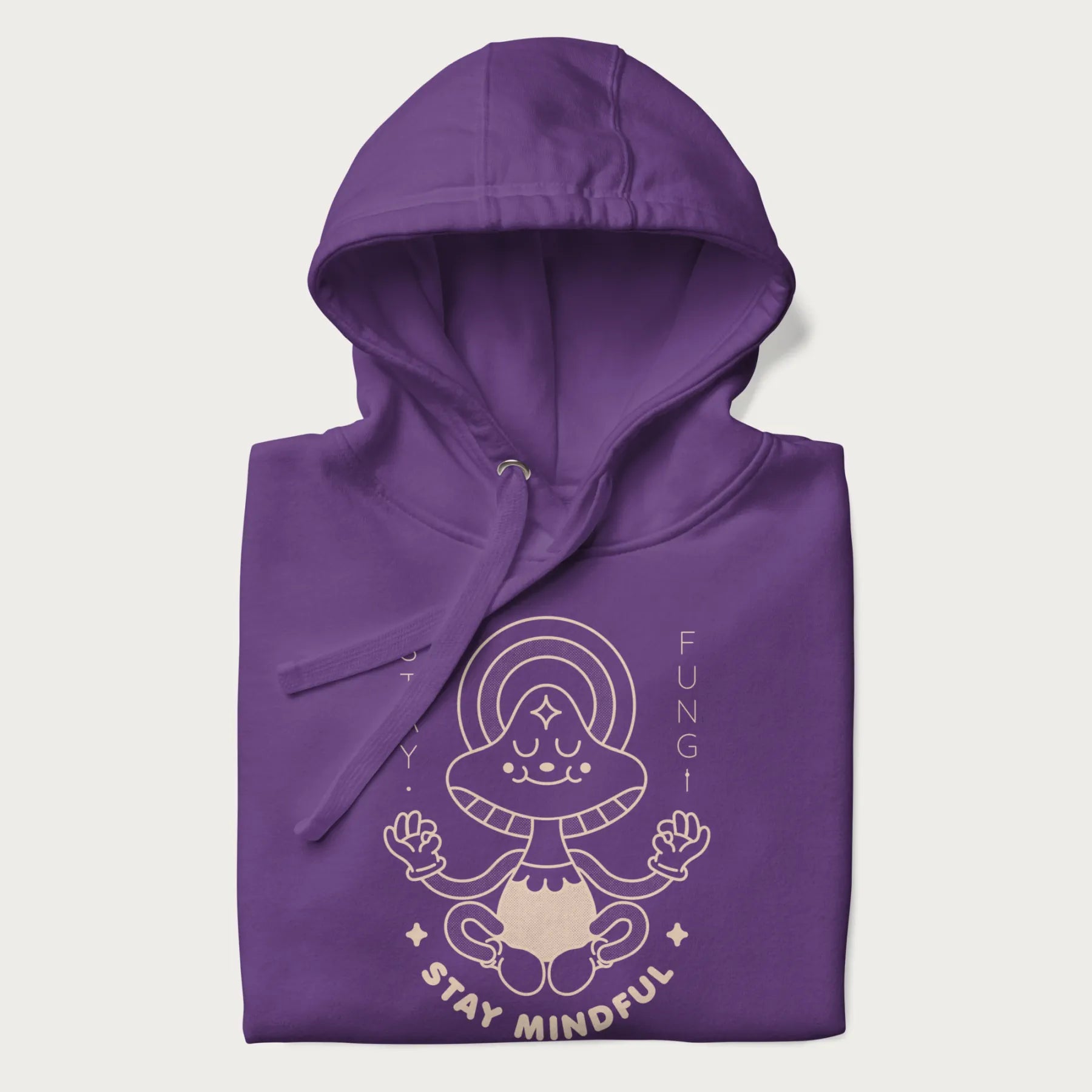 Folded purple hoodie with a graphic of a meditating mushroom character and the words 'Stay Fungi' and 'Stay Mindful'.