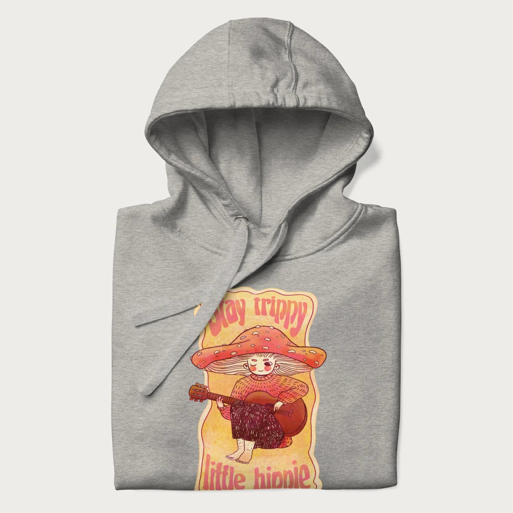 Folded light grey hoodie with a graphic of a character with a mushroom cap playing a guitar and the text 'Stay Trippy Little Hippie.'
