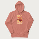 Light pink hoodie with a graphic of a character with a mushroom cap playing a guitar and the text 'Stay Trippy Little Hippie.'