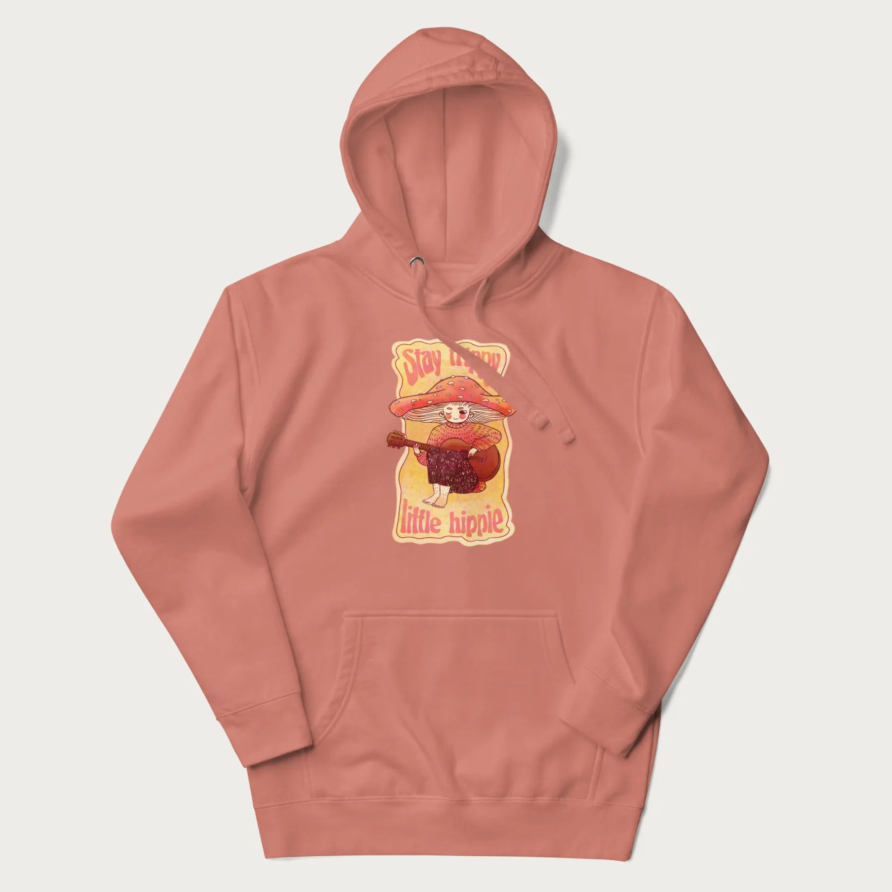 Light pink hoodie with a graphic of a character with a mushroom cap playing a guitar and the text 'Stay Trippy Little Hippie.'