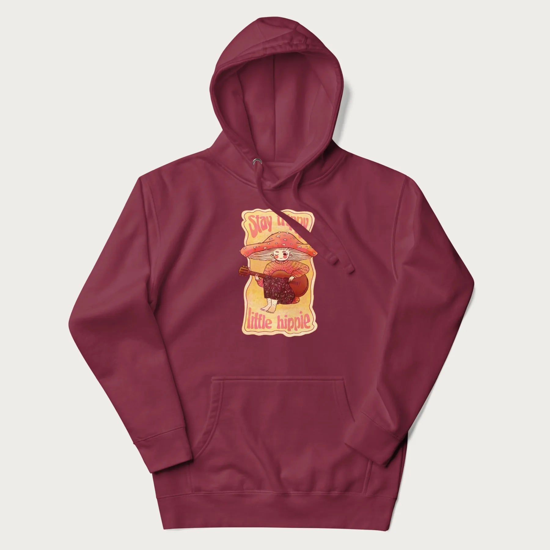 Maroon hoodie with a graphic of a character with a mushroom cap playing a guitar and the text 'Stay Trippy Little Hippie.'