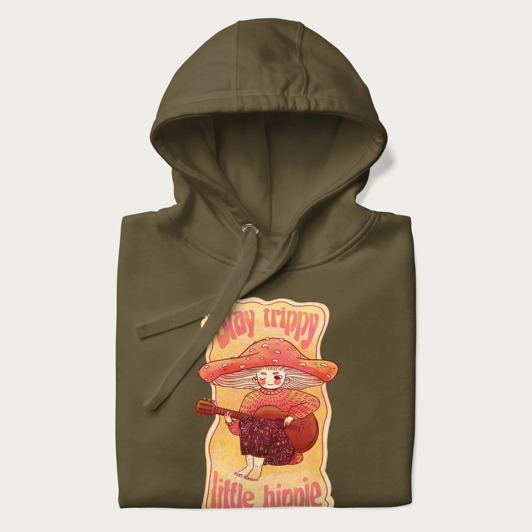 Folded military green hoodie with a graphic of a character with a mushroom cap playing a guitar and the text 'Stay Trippy Little Hippie.'
