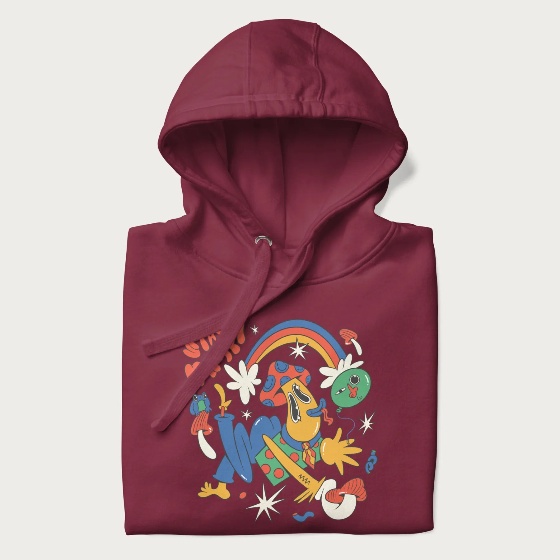 Folded maroon trippy hoodie featuring a colorful psychedelic design with playful characters and the text "Stay Trippy".