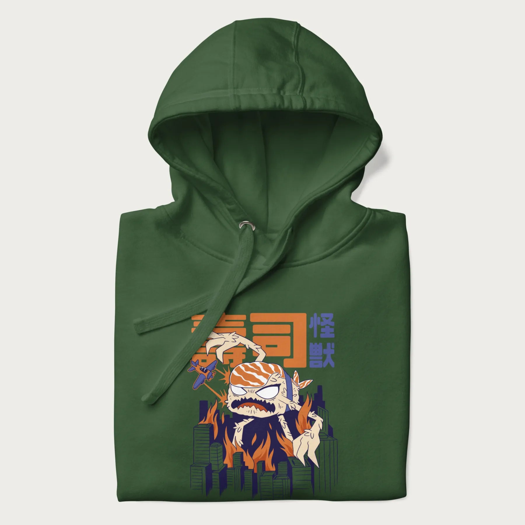 Folded forest green hoodie with Japanese graphic of a sushi monster over a burning city with Japanese text.