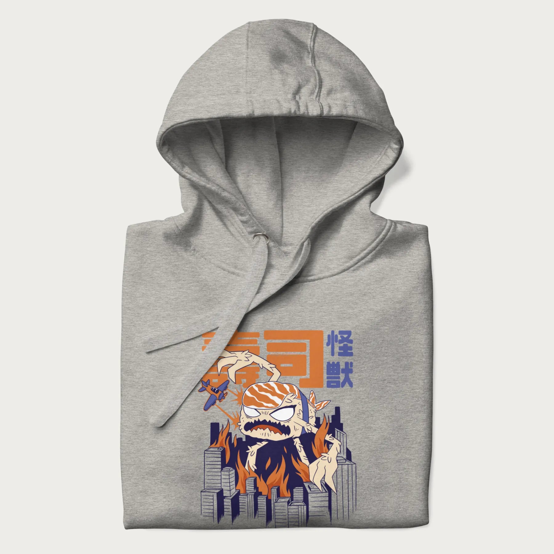 Folded light grey hoodie with Japanese graphic of a sushi monster over a burning city with Japanese text.