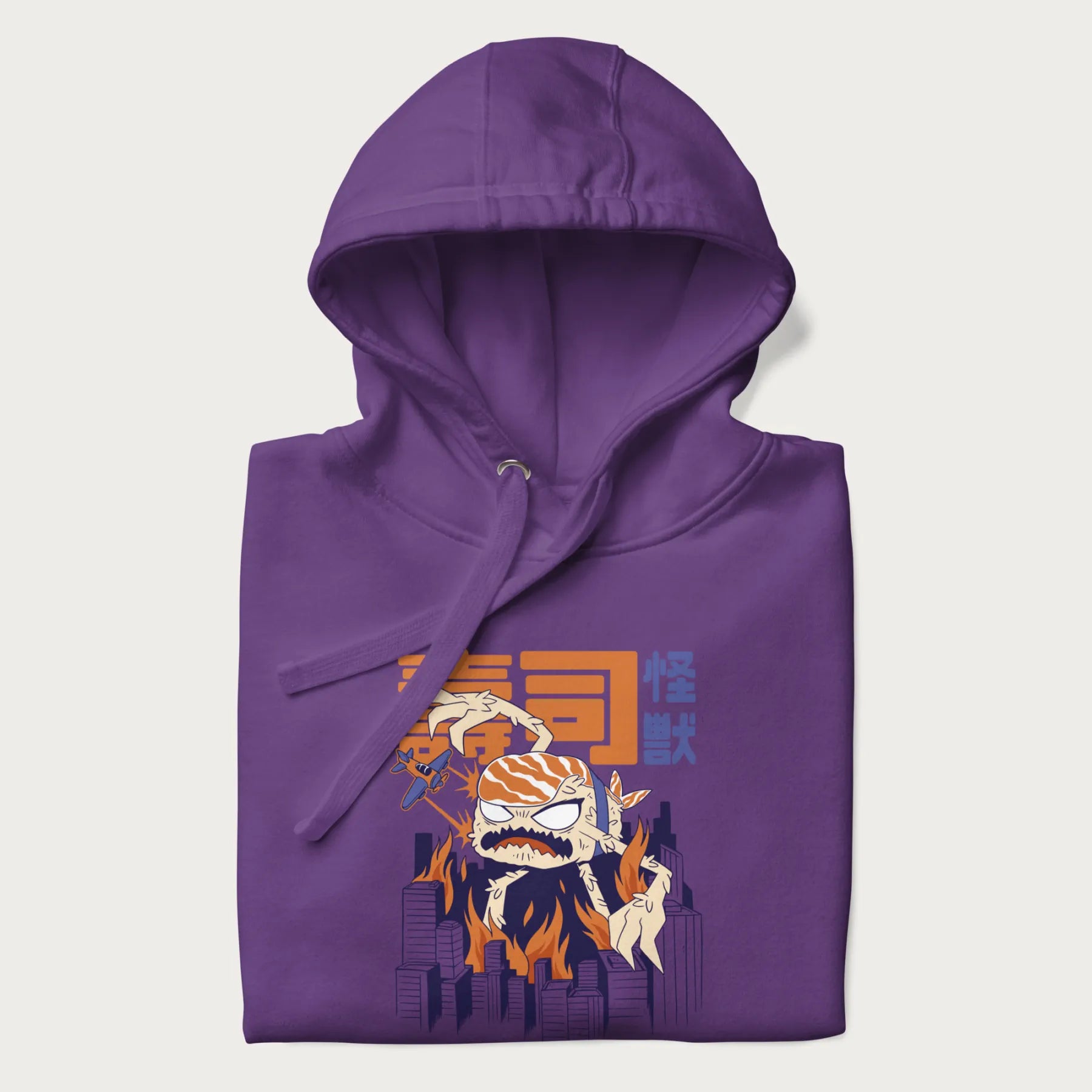 Folded purple hoodie with Japanese graphic of a sushi monster over a burning city with Japanese text.