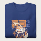 Folded royal blue sweatshirt with a graphic of a monstrous sushi roll attacking a city and Japanese text.