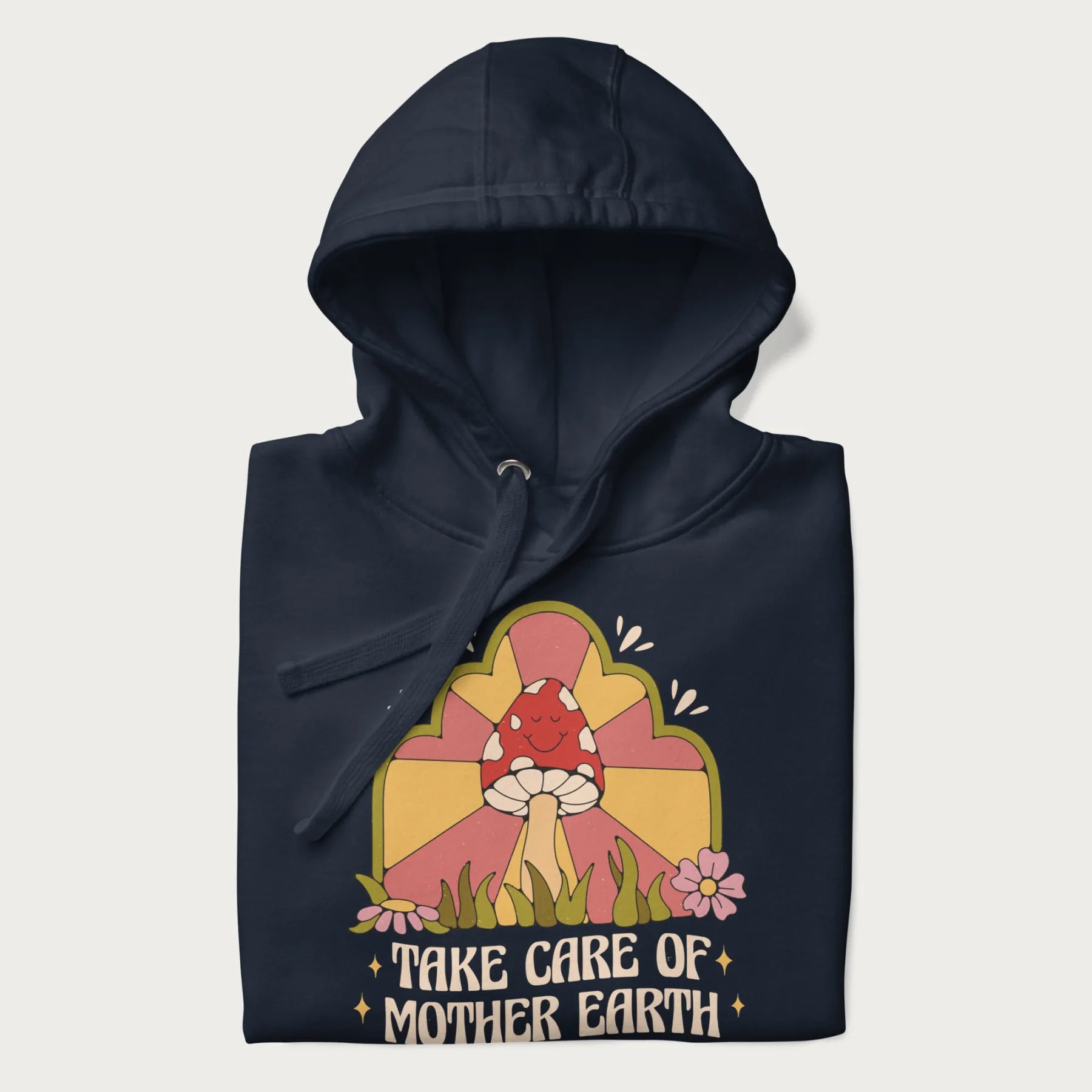 Folded navy blue hoodie with a graphic of a happy red mushroom, sunburst background, and the text 'Take Care of Mother Earth'.