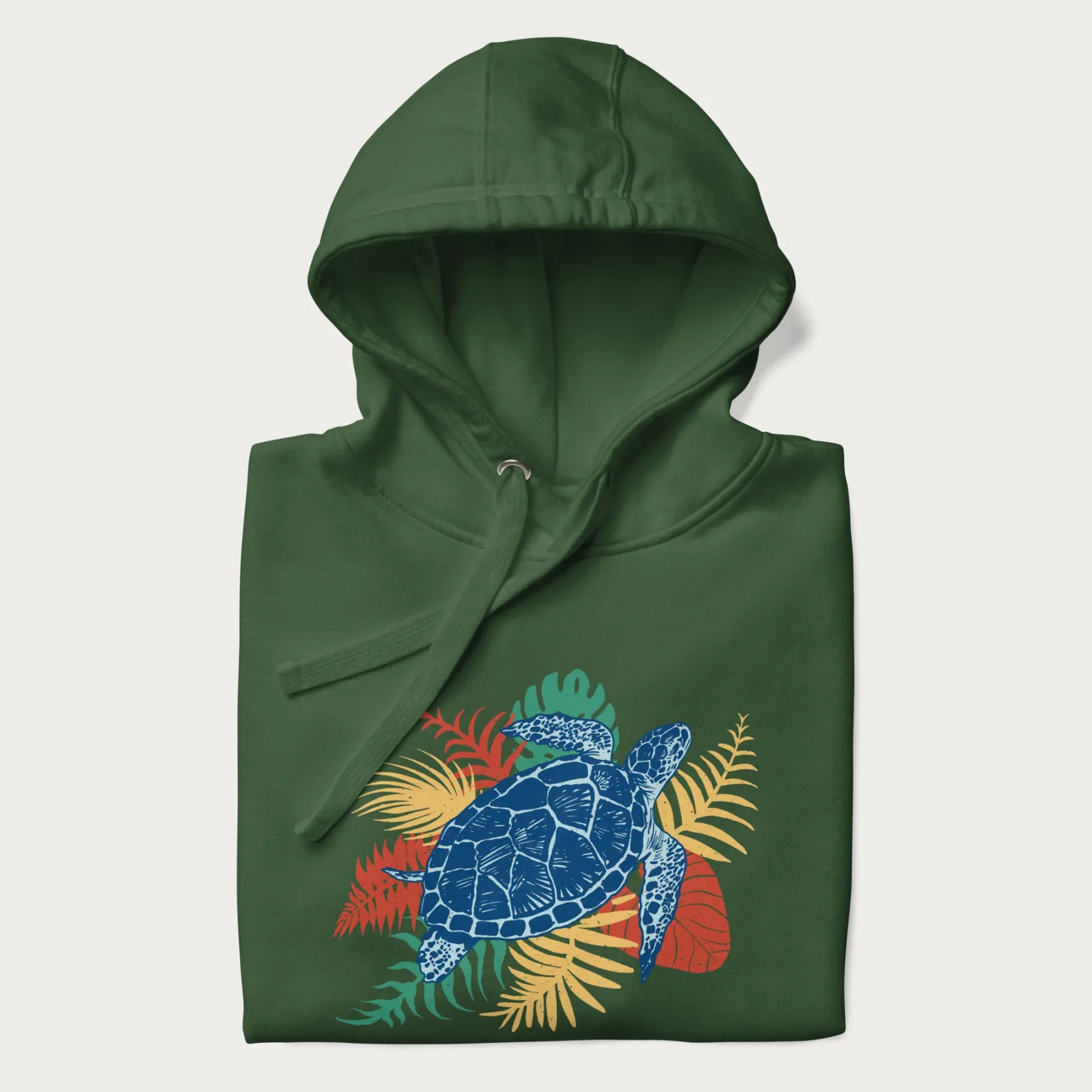 Folded forest green hoodie with a vibrant graphic of a blue sea turtle and colorful tropical leaves.