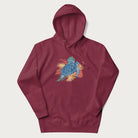 Maroon hoodie with a vibrant graphic of a blue sea turtle and colorful tropical leaves.