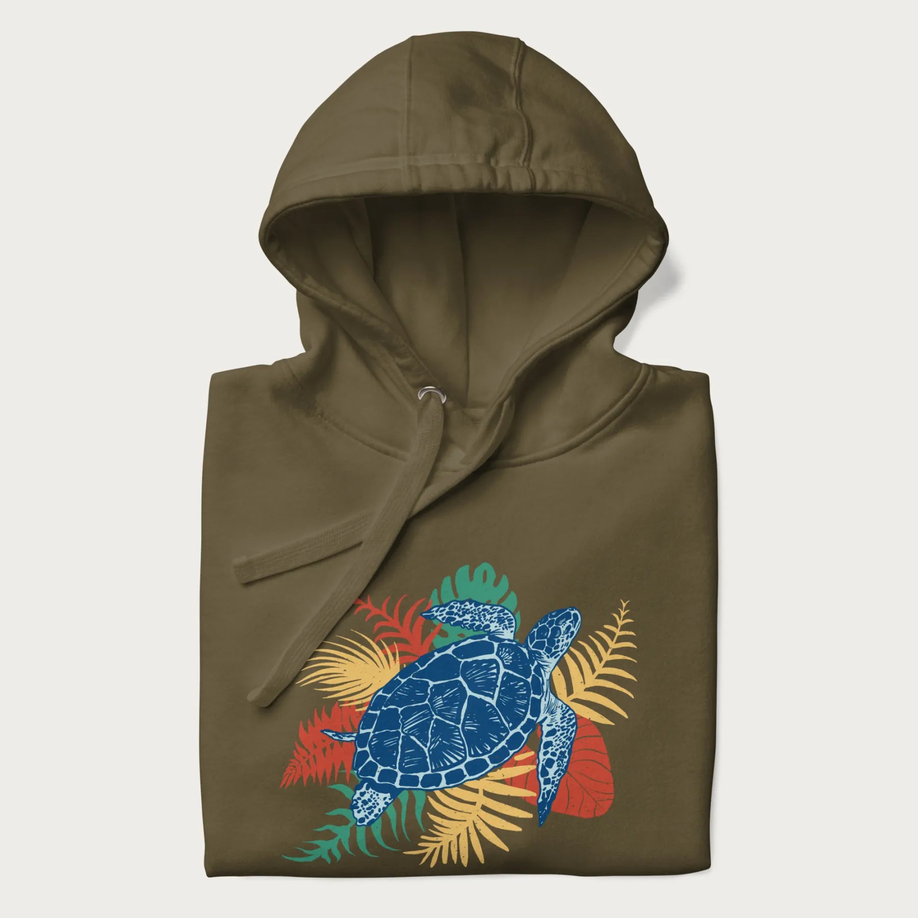 Folded military green hoodie with a vibrant graphic of a blue sea turtle and colorful tropical leaves.