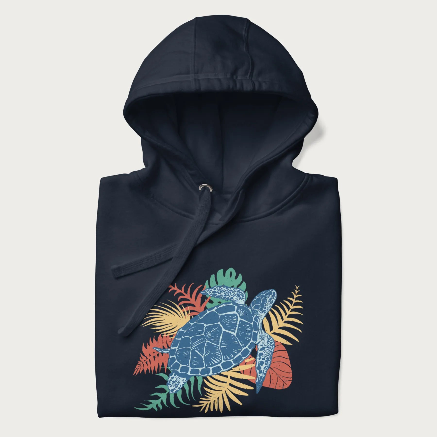 Folded navy blue hoodie with a vibrant graphic of a blue sea turtle and colorful tropical leaves.