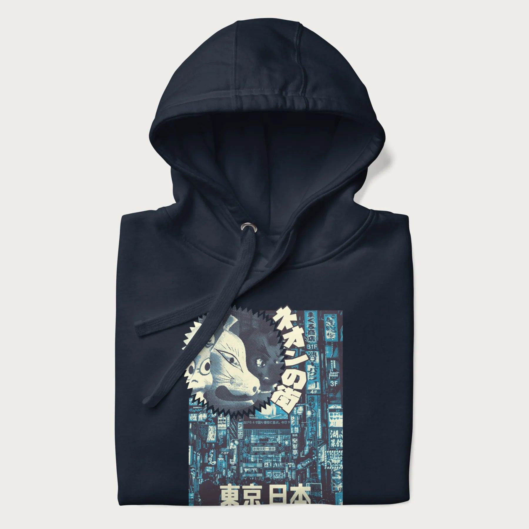 Folded navy blue hoodie with Japanese text '東京日本' translating to 'Tokyo, Japan', with three traditional Japanese masks over a neon-lit Tokyo background.