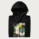 Folded black hoodie with Japanese text and a graphic of a retro-futuristic robot fighter, inspired by Japanese mecha art.