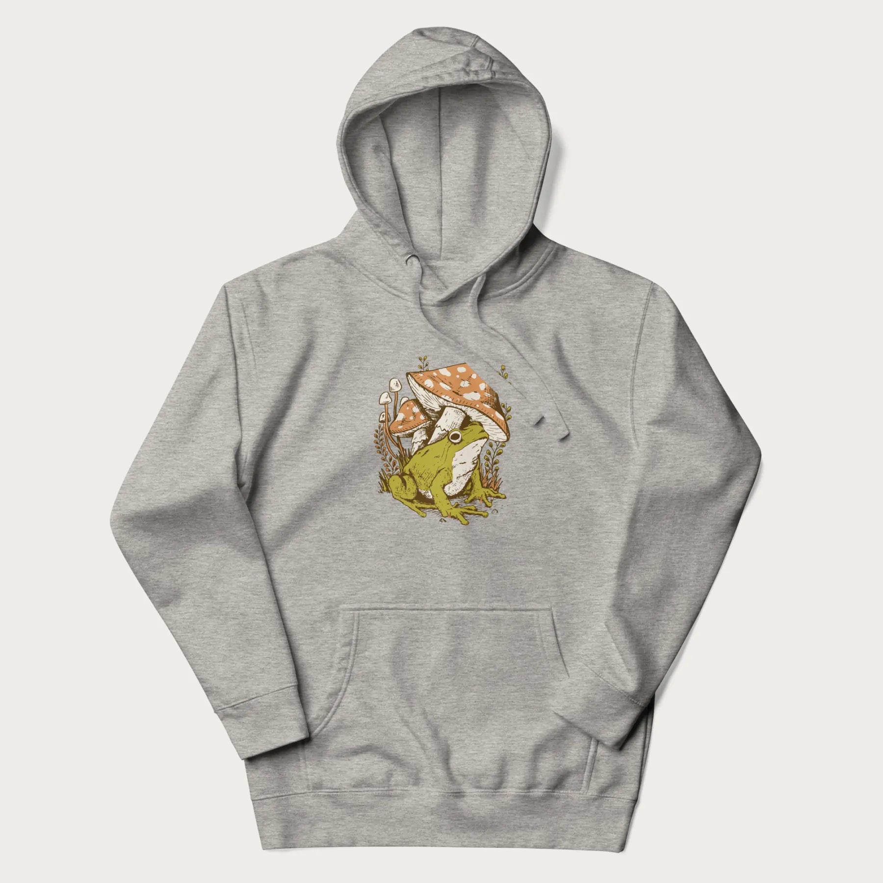 Light grey hoodie with cottagecore graphic of a frog under mushrooms with foliage in the background.