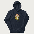 Navy blue hoodie with cottagecore graphic of a frog under mushrooms with foliage in the background.