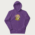 Purple hoodie with cottagecore graphic of a frog under mushrooms with foliage in the background.