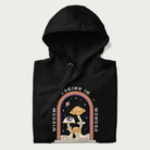 Folded black hoodie with graphic of mystical mushrooms with an all-seeing eye and the text 'Wisdom Begins in Wonder' framed by a rainbow arch.