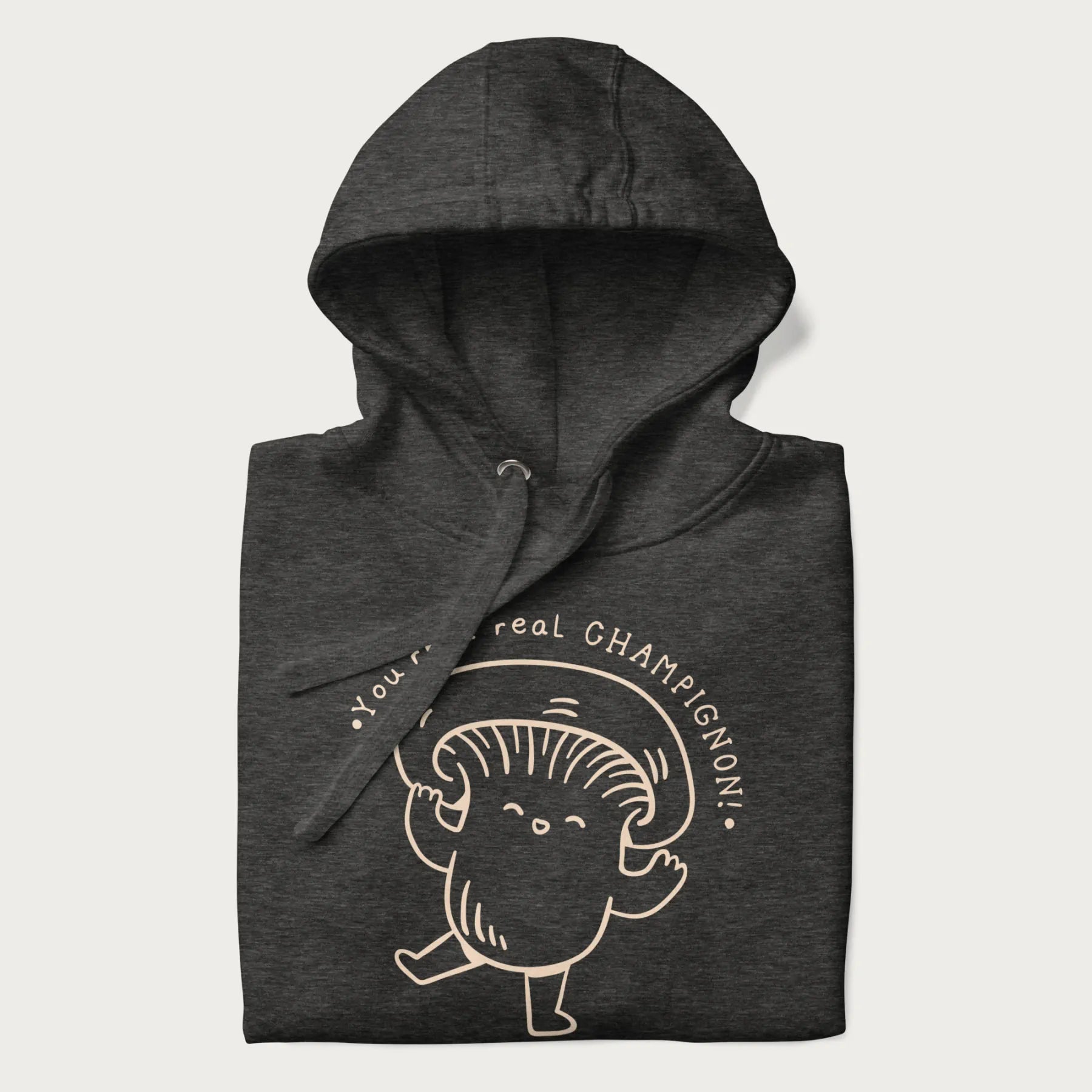 Folded dark grey hoodie with a cute champignon mushroom graphic and the text "You're a Real Champignon!"