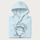 Folded light blue hoodie with a cute champignon mushroom graphic and the text "You're a Real Champignon!"