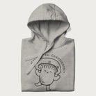 Folded light grey hoodie with a cute champignon mushroom graphic and the text "You're a Real Champignon!"