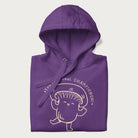 Folded purple hoodie with a cute champignon mushroom graphic and the text "You're a Real Champignon!"