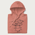 Folded light pink hoodie with graphic of a cute mushroom joyfully dancing with the text "You're a Real Fun-gi!"