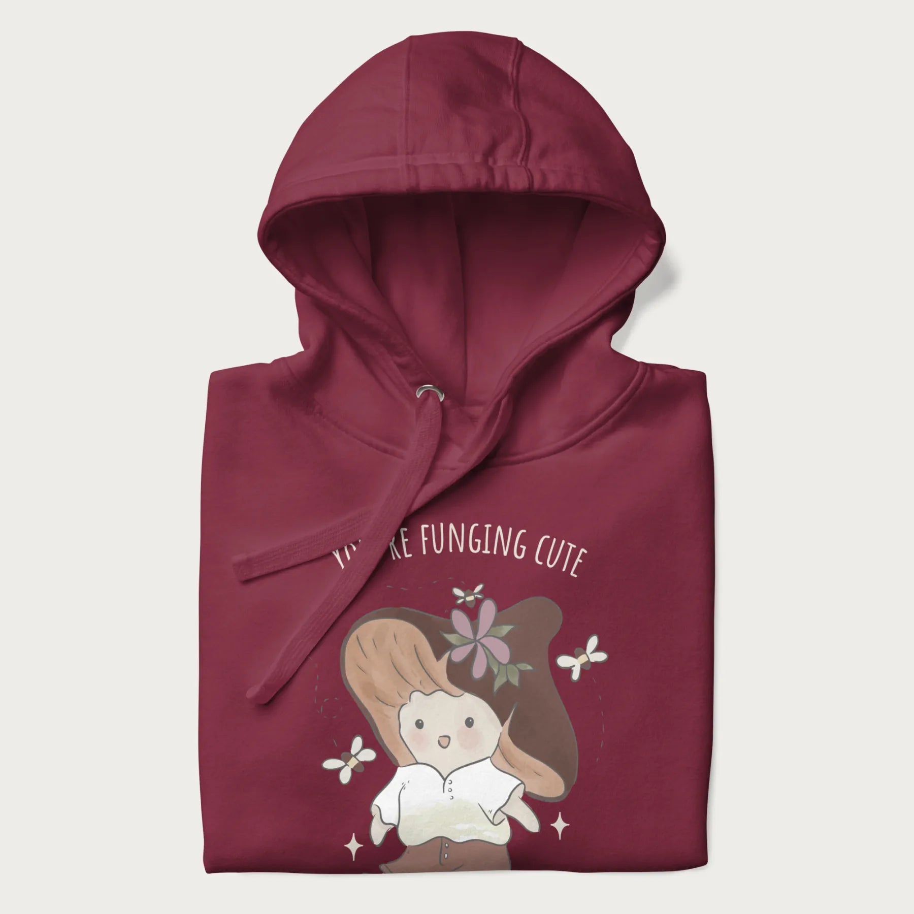Folded maroon hoodie with a cute mushroom character and the text 'You're Funging Cute' above.