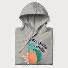 Folded light grey hoodie with a cute turtle graphic and the text 'You're Shella Cute' above.