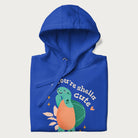 Folded royal blue hoodie with a cute turtle graphic and the text 'You're Shella Cute' above.