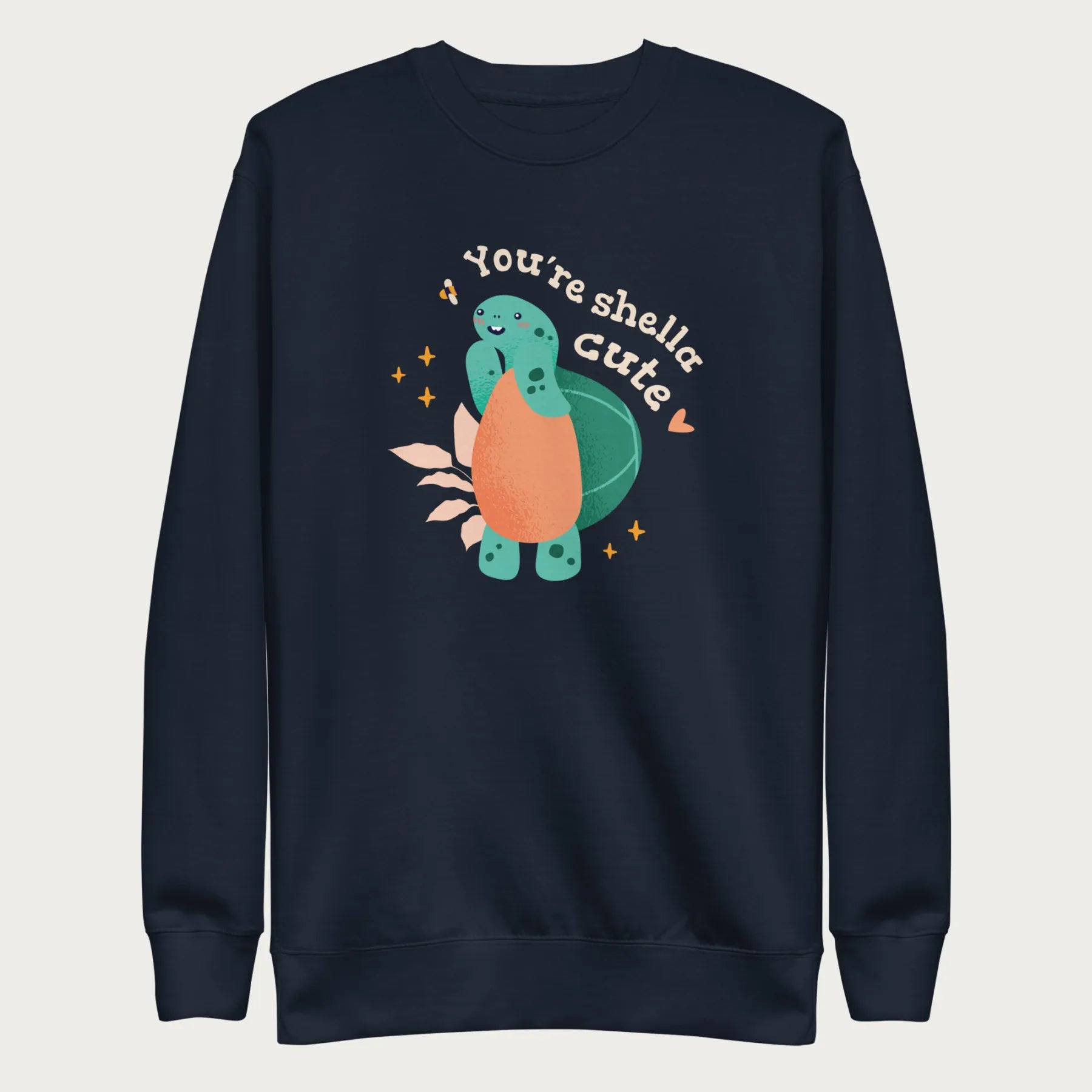 Navy blue sweatshirt with a cute graphic of a smiling turtle and bee with the phrase 'You're Shella Cute.'